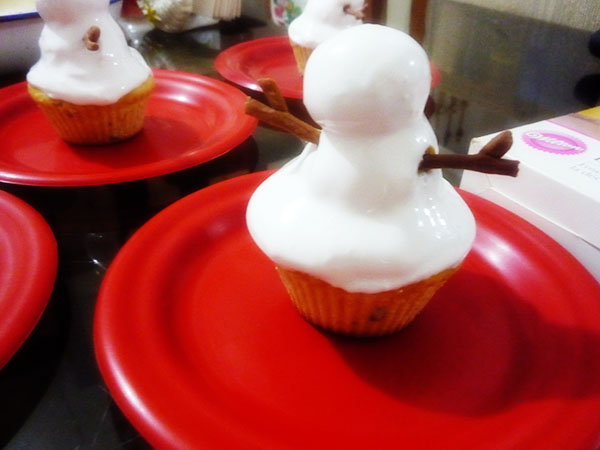 Muñeco de nieve con profiteroles y cupcakes de vainilla casi listo